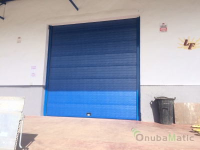 Instalación de puerta industrial lacada en ral 5010 en las instalaciones de Lucena Fruit en Lucena del Puerto (Huelva)