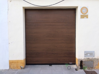 Instalación de puerta seccional imitación madera automática en Palos de la Frontera (Huelva).