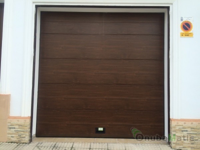 Instalación en Moguer (Huelva) de puerta automatica seccional imitación madera unicanal liso.