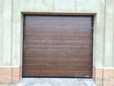 Puerta automatica seccional imitación madera instalada en La Palma del Condado-Huelva.