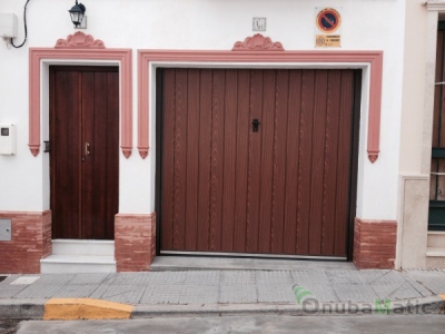 Puerta basculante no desbordante con de madera werzalit instalada en Trigueros.
