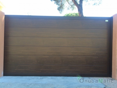 Puerta corredera de panel seccional imitacion madera unicanal con marcos de aluminio, Bellavista(Huelva)