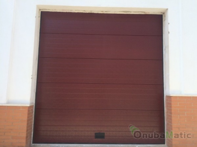 Puerta seccional automatica en ral 3005 instalada en Gibraleón (Huelva)