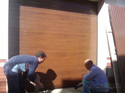Puerta seccional automática imitacion madera en vivienda unifamiliar en Gibraleón.