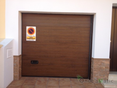 Puerta seccional automática imitacion madera en vivienda unifamiliar en Niebla.