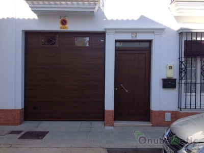 Puerta seccional automática imitacion madera uniacanalado liso con puerta PVC instalada en Moguer