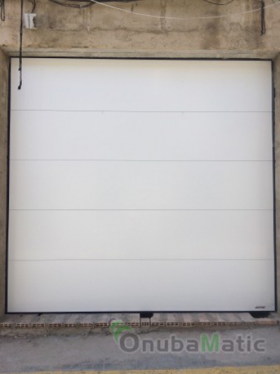 Puerta seccional automatica instalada en Moguer (Huelva). Panel liso lacado en blanco.