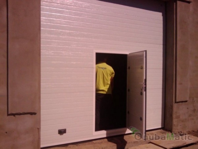 Puerta seccional automatica lacada en blanco con puerta peatonal en vivienda unifamiliar en Escacena del Campo