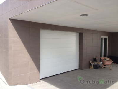 Puerta seccional automatica lacada en blanco  en vivienda unifamiliar en Moguer.