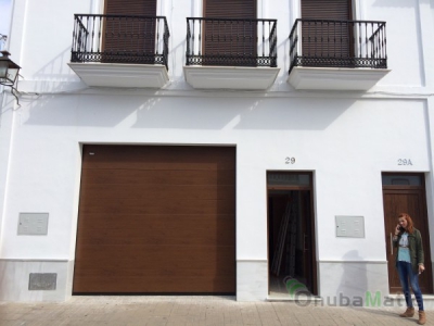 Puerta seccional en imitación madera modelo uniacanalado liso instalada en Moguer.