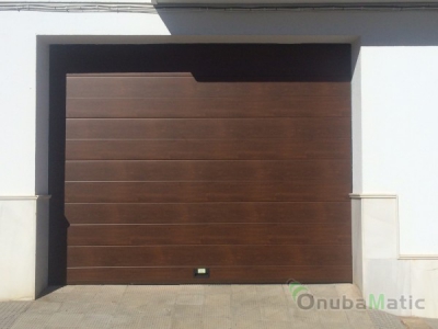 puerta seccional imitación madera nogal panel unicanal liso instalada en Palos de la Frontera (Huelva)