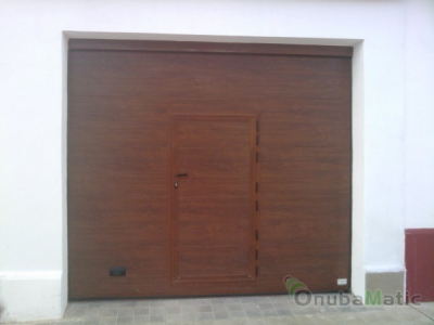 puerta seccional initación madera con puerta peatonal instalada en Gibraleón
