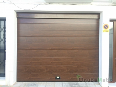 Puertan seccional imitación madera panel unicanal liso instalada en Moguer (Huelva)