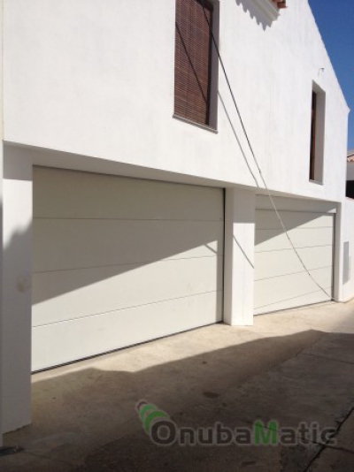 Puertas seccionales lacadas en blanco tablon liso para viviendas unifamiliares en Villanueva de los Castillejos.